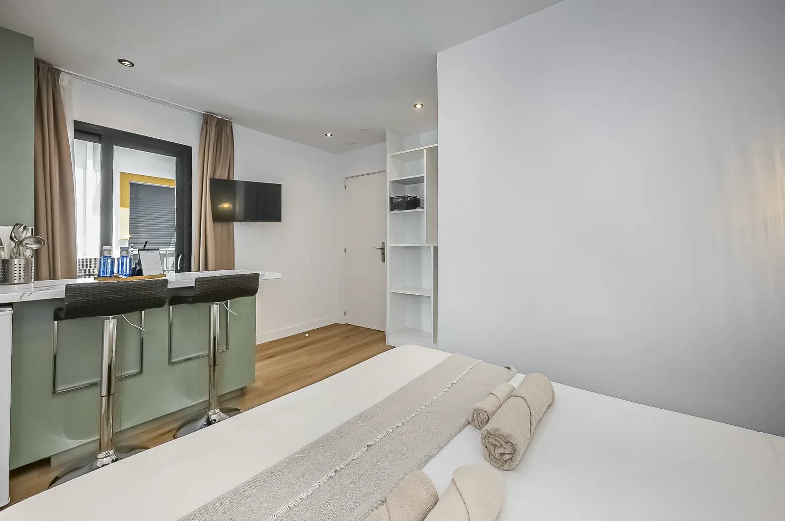 The Signature Suite breakfast bar with two stools, beside the window onto the lane
